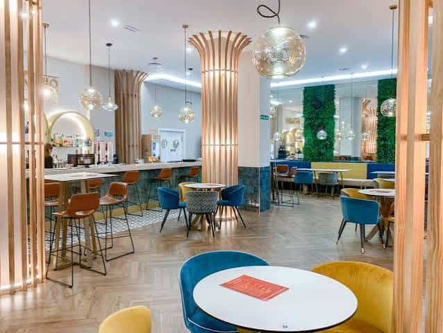 Interior moderno del hotel con barra, mesas y decoración contemporánea
