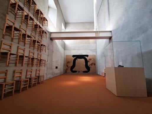 Interior de la Sala de Reflexión con sillas apiladas en la pared