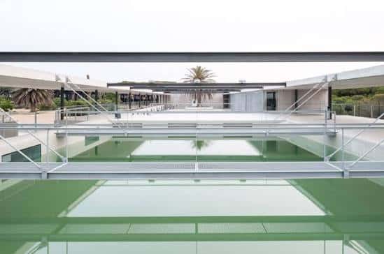 Vista exterior del edificio de CRAM con su característica piscina verde y estructura arquitectónica moderna