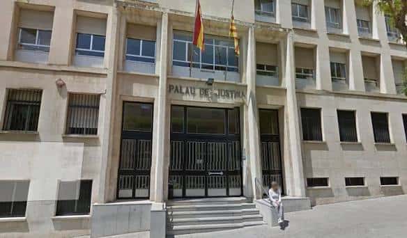 Fachada principal del Palau de Justícia con banderas española y catalana