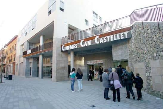 Fachada principal de Cinemes Can Castellet con cartel visible y personas en la entrada