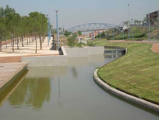 Canal del parque con puente metálico al fondo