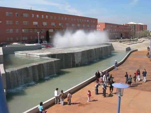 Escultura de agua con cascadas y personas disfrutando