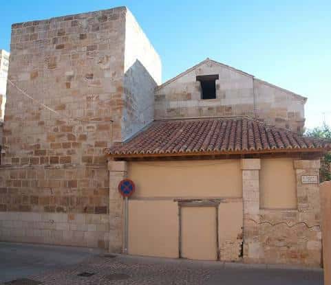 Vista exterior de la Iglesia de San Leonardo con su fachada de piedra y tejado a dos aguas