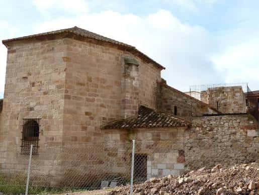 Ángulo lateral de la iglesia mostrando muros de sillería y entorno en obras
