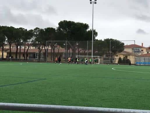 Campo de fútbol del complejo deportivo con jugadores en entrenamiento
