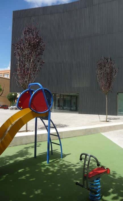 Área de juegos infantiles frente al edificio del centro cívico