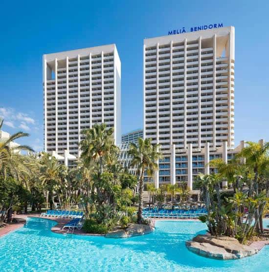 Vista frontal de las torres gemelas del Meliá Benidorm con piscina y palmeras