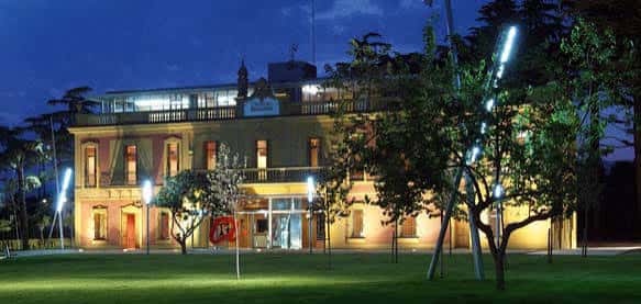 Fachada iluminada del palacio de Mas Miarnau durante la noche, ideal para eventos