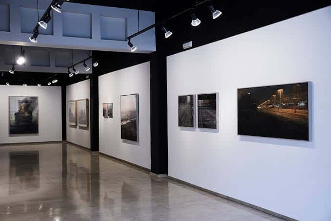 Interior de la galería con obras de arte expuestas en las paredes