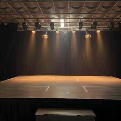 Escenario vacío de la escuela con iluminación profesional y cortinas negras