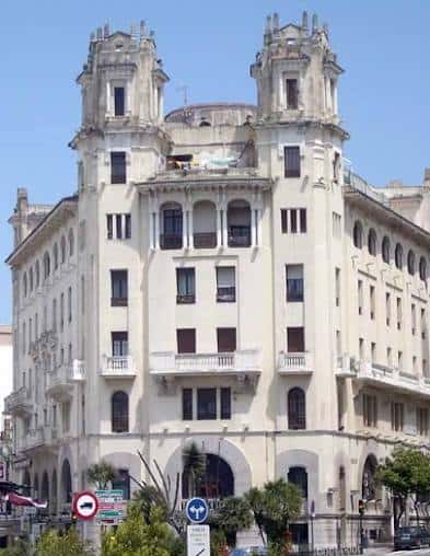 Fachada imponente de un edificio histórico en el Paseo del Revellín con torres ornamentales