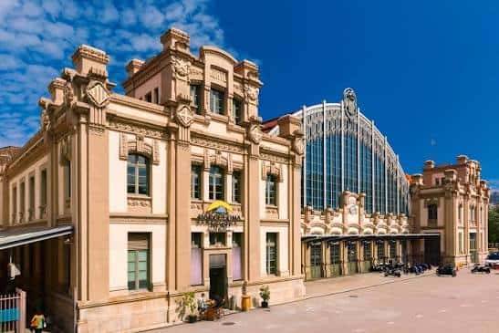 Vista exterior de la Estación de Autobuses Barcelona Nord con fachada histórica y estructura moderna bajo cielo azul