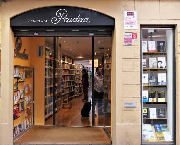 Vista exterior de la Llibreria Paideia con su fachada característica y escaparate iluminado