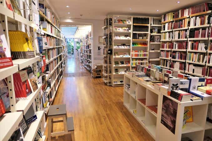 Interior acogedor de la librería con estanterías llenas de libros y suelo de madera