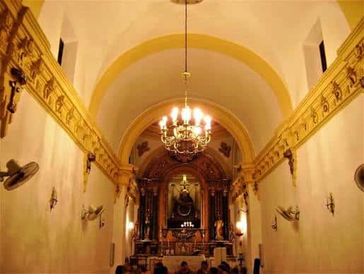 Interior de la ermita con bóveda y altar principal iluminado