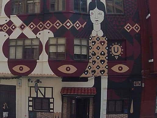 Fachada exterior del local Universonoro con un mural artístico de estilo folk