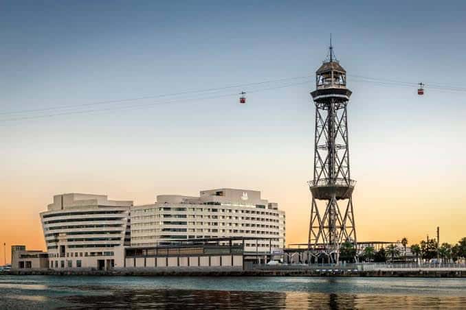 Vista exterior del Eurostars Grand Marina Hotel en Barcelona con la Torre de Telecomunicaciones al atardecer