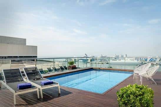 Piscina en la azotea del hotel con vistas al puerto y tumbonas para relajación