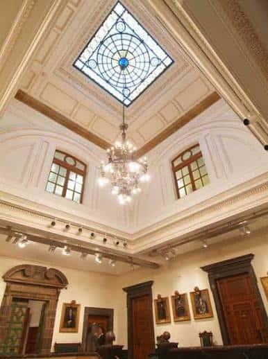 Interior del salón principal con cúpula de cristal y lámpara de araña