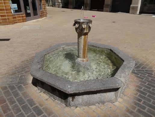 Fuente octogonal de piedra en el centro de la plaza