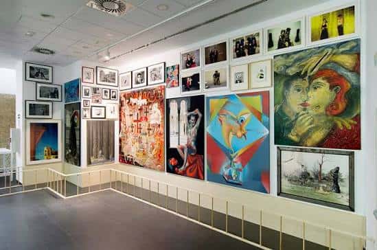 Galería de arte con múltiples cuadros y obras expuestas en las paredes