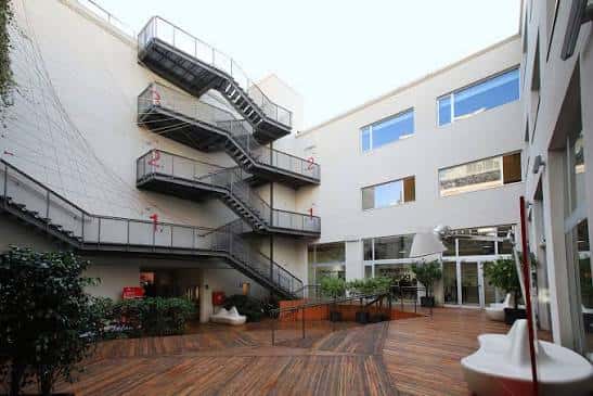 Patio interior del IED Barcelona con escaleras metálicas y zona de descanso