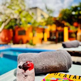 Vista relajante de la piscina con toallas y una bebida refrescante