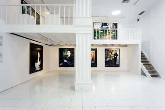 Sala de exposiciones interior con obras colgadas