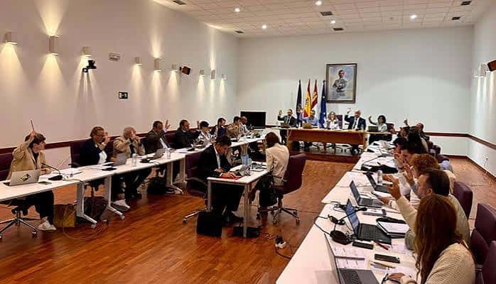 Sala de reuniones con mesa en forma de U y banderas