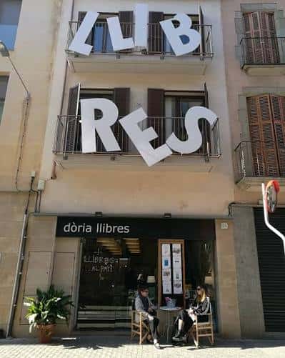 Fachada de Dòria Llibres con grandes letras blancas en los balcones