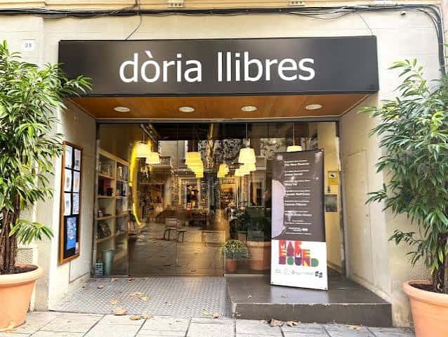 Entrada principal de la librería con letrero negro y plantas a los lados