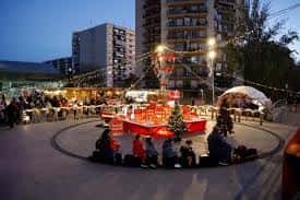 Plaza decorada para la feria navideña con luces y puestos
