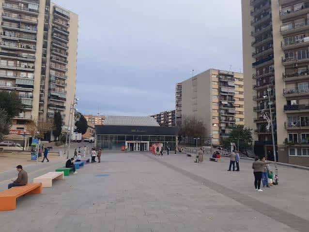 Vista general de la plaza Nova Estació con bancos y edificios residenciales