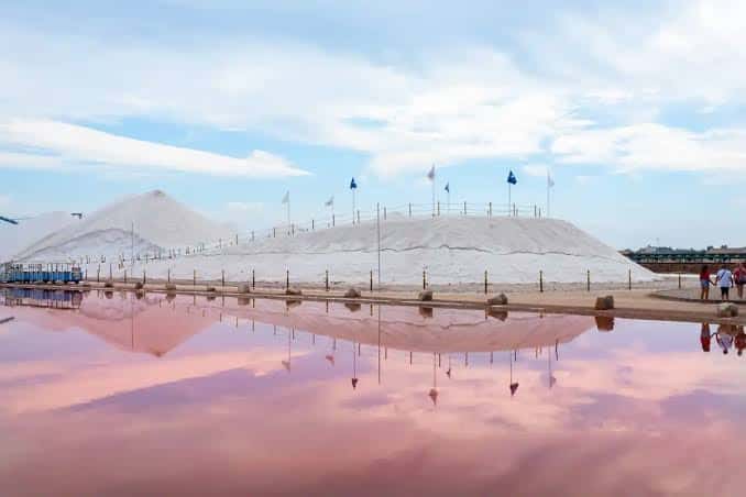 Vista panorámica de las Salinas con montañas de sal y reflejo en la laguna rosa
