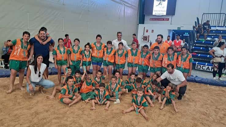 Grupo de luchadores canarios posando con medallas en el terrero de lucha Heraclio Niz