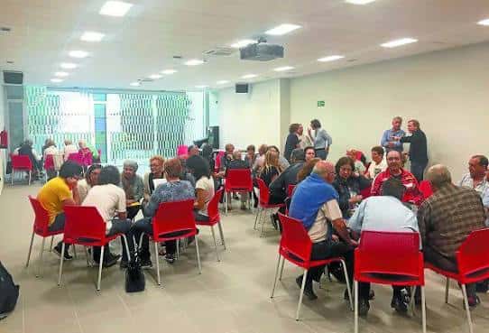 Interior del espacio durante un evento social con asistentes reunidos en mesas