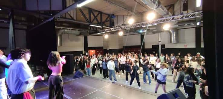 Evento en vivo en la sala grande con jóvenes bailando bajo iluminación profesional