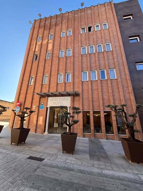 Fachada principal del Hotel Nova Roma en Mérida con entrada y macetas decorativas