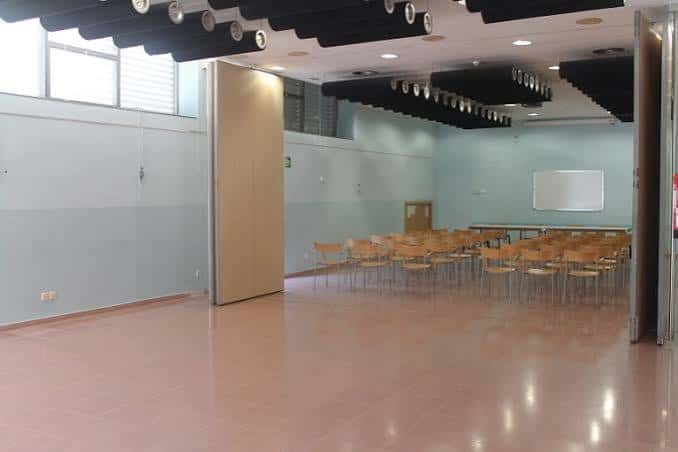 Sala polivalente interior con sillas dispuestas para eventos o conferencias