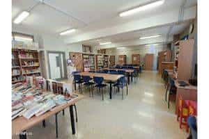 Interior de la sala de lectura con mesas y estanterías organizadas