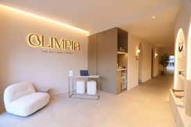 Recepción moderna del centro Olimpia con iluminación cálida y diseño minimalista