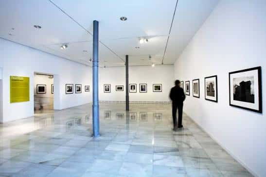 Vista general del interior de la Sala d'Exposicions con paredes blancas y suelo de mármol