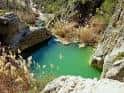 Charca verde rodeada de rocas en el entorno natural