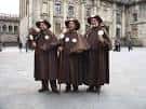 Grupo de tres peregrinos tradicionales en la Plaza del Obradoiro de Santiago