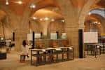 Sala de exposiciones del museo con arcos de piedra y vitrinas