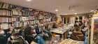 Interior de la librería Lila de Lilith durante un evento con asistentes sentados y estanterías
