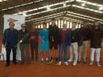 Grupo de personas en una pista de tenis cubierta con techo de estructura metálica