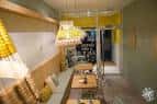 Interior del área de bar con mesas y bancos de madera