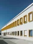 Fachada lateral moderna del CEIP Sagrado Corazón con ventanas enmarcadas en amarillo